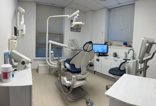 A dentist office with a surgical chair, teeth cleaning equipment and an X-ray machine all nearby.